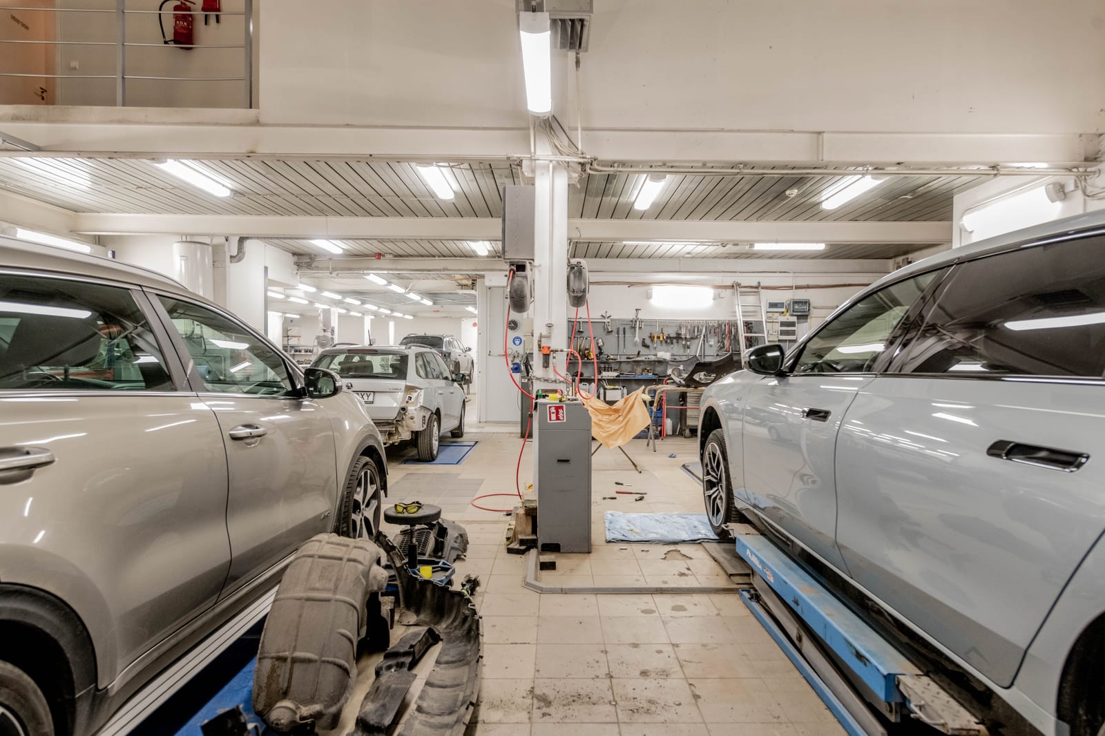 Interior of a working auto repair shop with cars raised in adjacent service bays