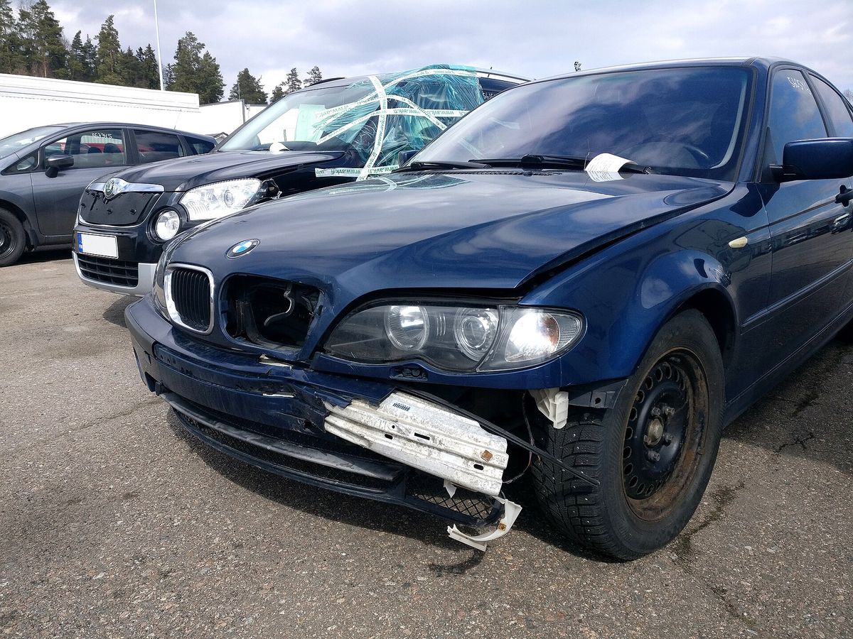 A broken front bumper on a car with cracked plastic and paint damage from a collision