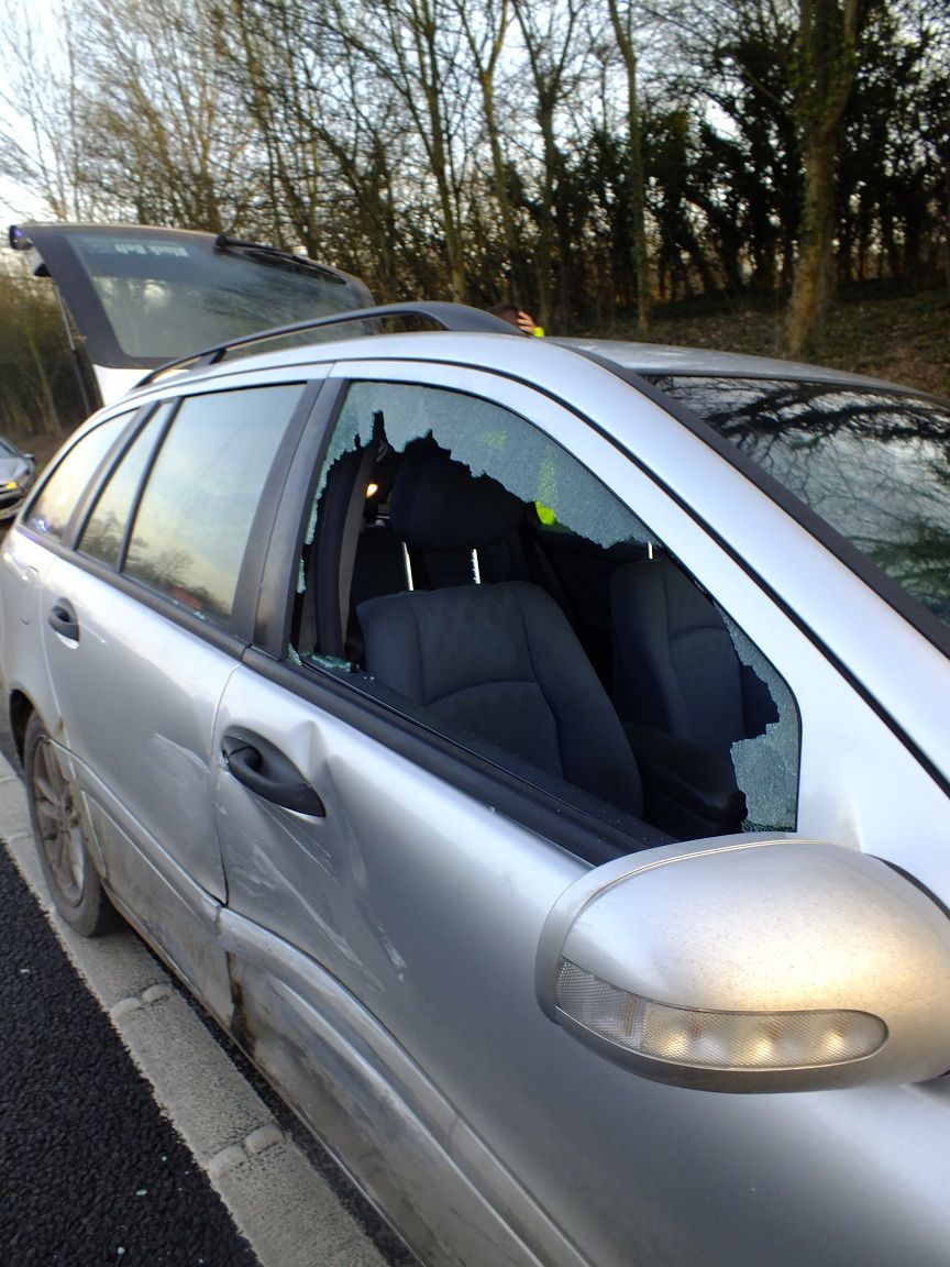 A Mercedes-Benz sedan with a visible dent and collision damage on a body panel