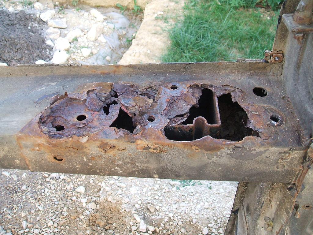 Close-up of rust corrosion eating through a vehicle chassis frame section