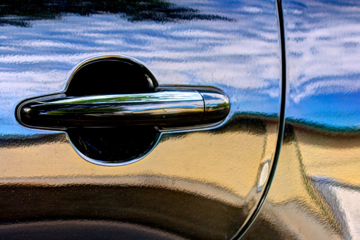 Textured, bumpy paint surface known as the orange peel effect on a repainted car panel