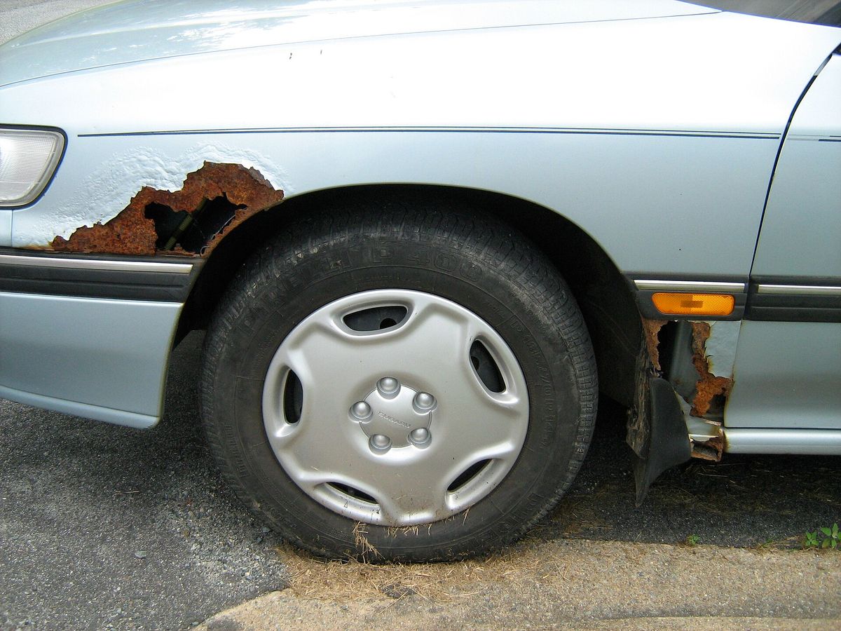 Rust deterioration spreading across a car fender