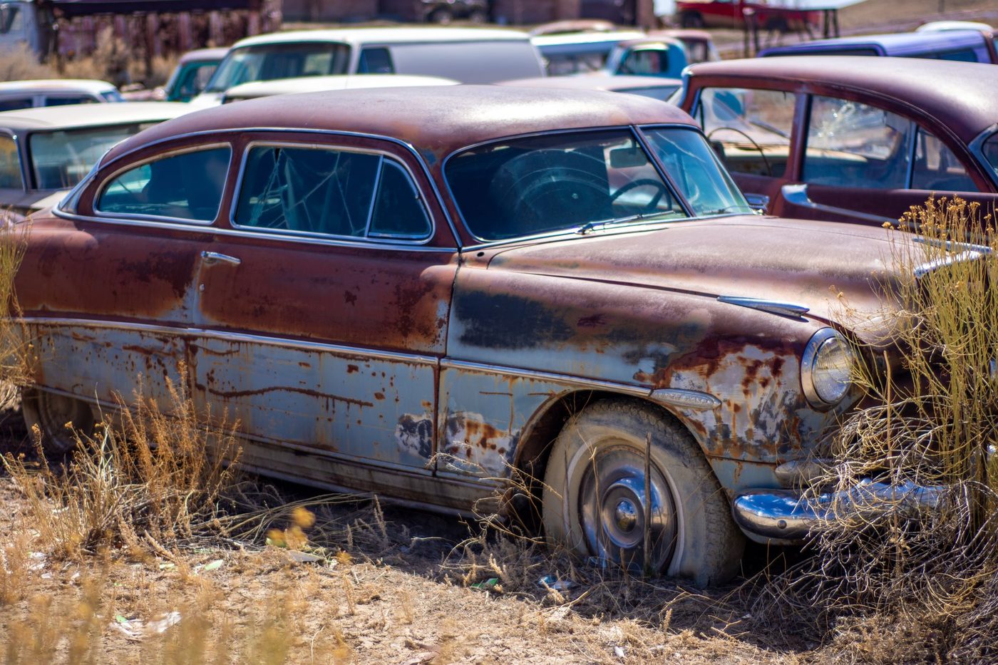 Close-up of severe, scaling rust corrosion on a classic car body left in a junkyard