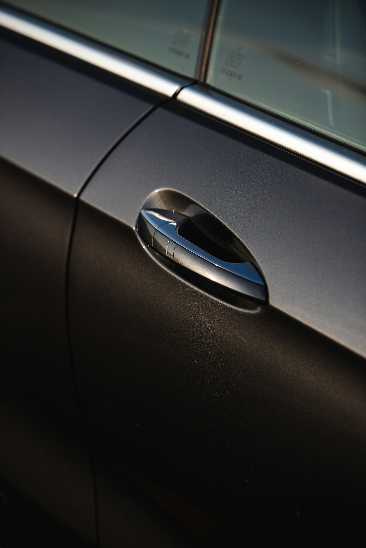 Close-up of a car door and handle in low light