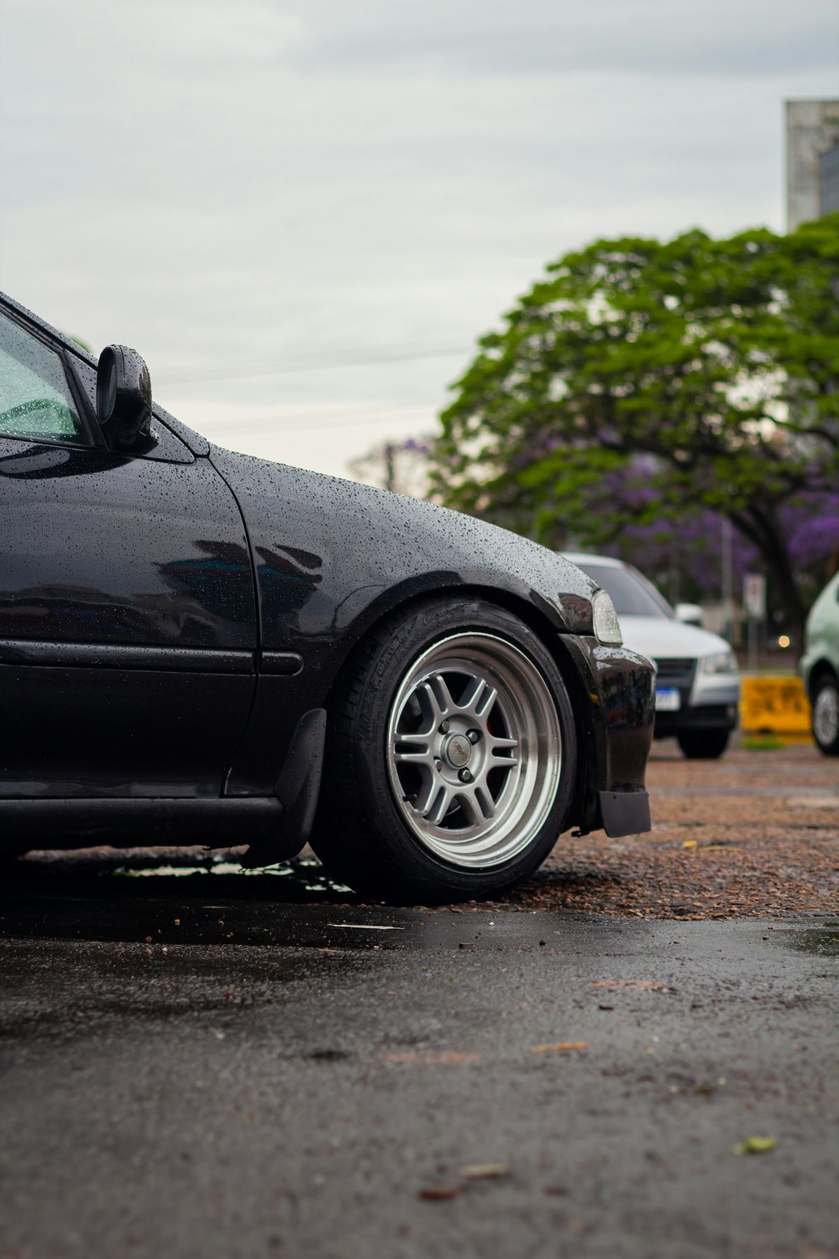 A black car with a dent and visible damage on the front end