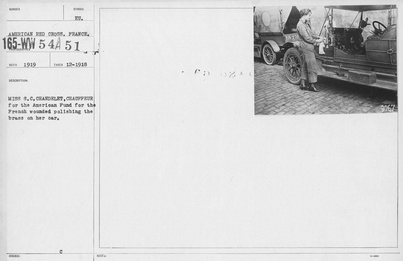 A World War I era American Red Cross chauffeur polishing the brass on her car by hand